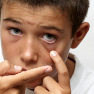 A child trying to wear a contact lens